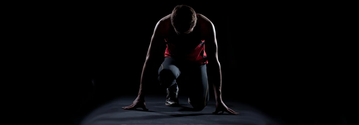 Man crouched in a starting position for a race.